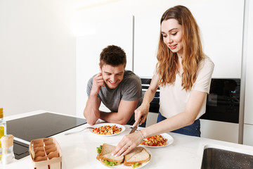 Smiling young couple cooking lunch together