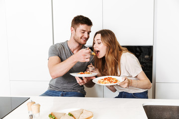 Smiling young couple eating breakfast together