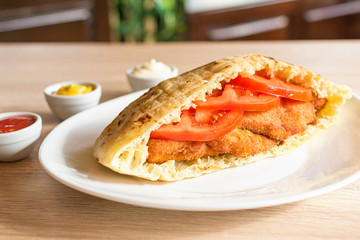 Delicious crispy chicken in pita bread with fresh salad ingredients