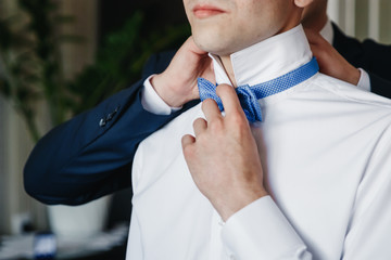 Man, the groom in a white shirt on the background of the apartment. Wedding, gathering of the groom, the creation of a family.