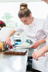 Confectioner putting chocolate as frosting on cake