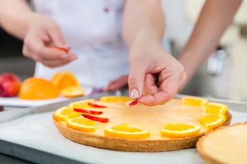 Obstkuchen wird von zwei Konditor Frauen gebacken 