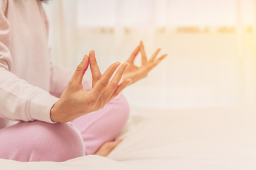 Asian women play yoga on bed in morning.color tone