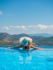 Woman enjoying relaxation in pool and looking at the view