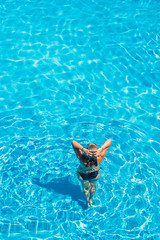 woman relaxing in infinity pool at luxury resort spa retreat.