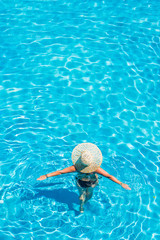 woman relaxing in infinity pool at luxury resort spa retreat.