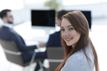 smiling female assistant in the background of the office