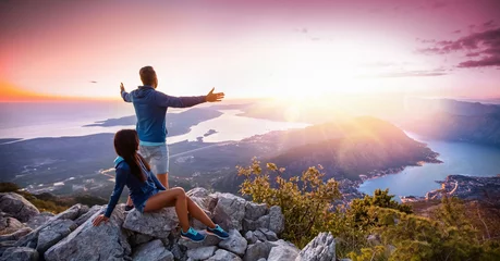 Foto op Canvas Happy couple watching the sunset in the mountains © Pasko Maksim 