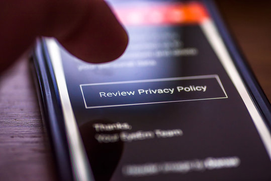 General Data Protection Regulation - GDPR - closeup human finger pointing to smartphone message with button Review Privacy Policy