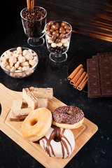 Unhealthy but delicous sweets and pastry on dark wooden background in studio photo