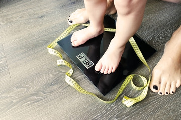 Help your child to have a healthy diet and lifestyle, with obese kid feet on weight scale, under...