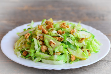 Cabbage slaw with pear and walnuts. Quick pear and cabbage slaw on a plate. Vitamin rich food