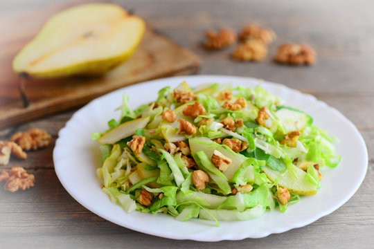 Home cabbage slaw with pear and walnuts. Healthy pear and cabbage slaw on a plate. Great food for getting vitamins. Closeup