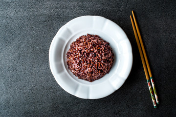 Cooked Black Rice in white Plate with Chopsticks.