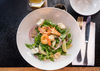 Starter with shrimps, brie, fresh salad leaves and vegetables