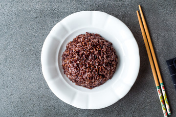 Cooked Black Rice in white Plate with Chopsticks.