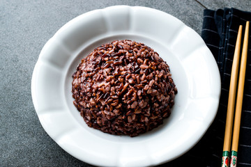 Cooked Black Rice in white Plate with Chopsticks.
