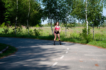 Roller skating woman in park rollerblading on inline skates. Beautiful woman learns to roller skate...