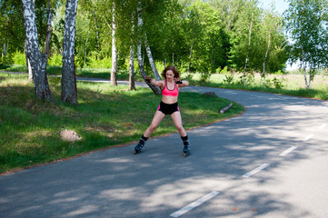 Roller skating woman in park rollerblading on inline skates. Beautiful woman learns to roller skate...