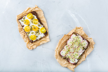Variety of sandwiches with cream cheese, radish, tomatoes and micro greens