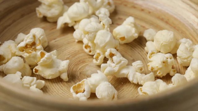 Close up of popcorn falling into bowl. No sound.