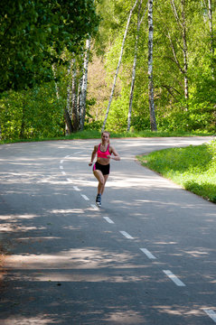 Beautiful smiling woman running in the park in the morning. Fitness girl running in the park. Running woman. Female Runner Jogging during Outdoor Workout in a Park. Beautiful fit Girl.