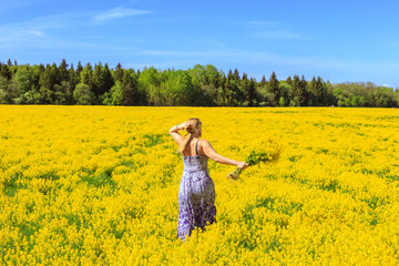 Fototapeta premium Girl running across the yellow field.