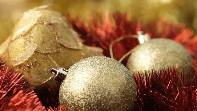 Close up of rotating gold baubles on christmas decoration with wind effect. No sound.