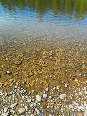 stones on the river Bank with clear water where the bottom is visible