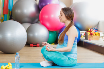 Fototapeta premium Pregnant woman makes yoga exercise on the mat