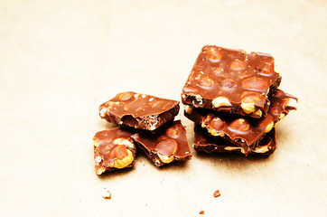 milk chocolate with whole nuts on paper background