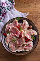 Dumplings, filled with strawberries. Pierogi, varenyky, vareniki, pyrohy - dumplings with filling. View from above, top, overhead
