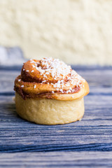 kanelbulle med pärlsocker på rustikt trä bord