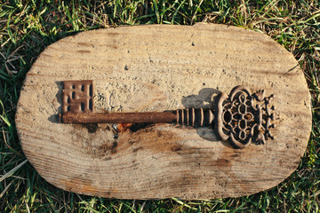 Old ornate skeleton key on rough wood background