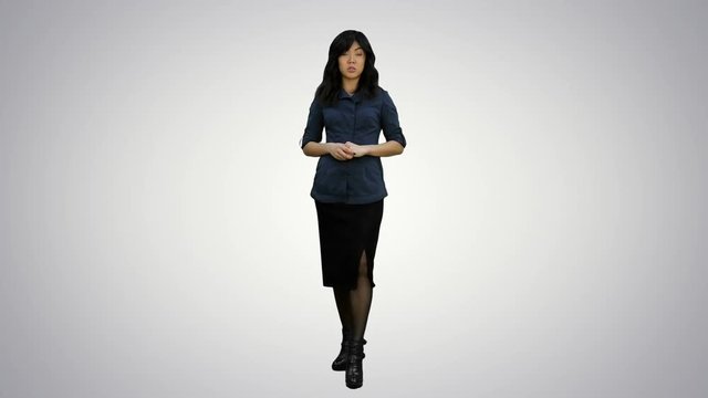 Young attractive asian woman talks to camera, presenting something on white background