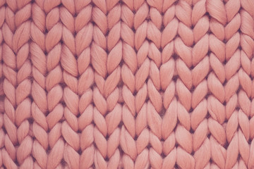 Texture of pink knit blanket. Large knitting. Plaid merino wool. Top view