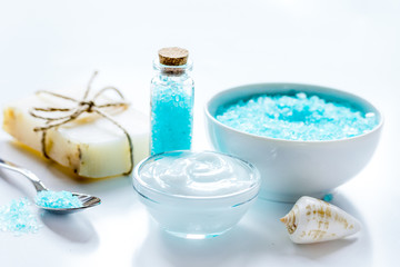 Plakat blue set for bath with salt and shells on white table background