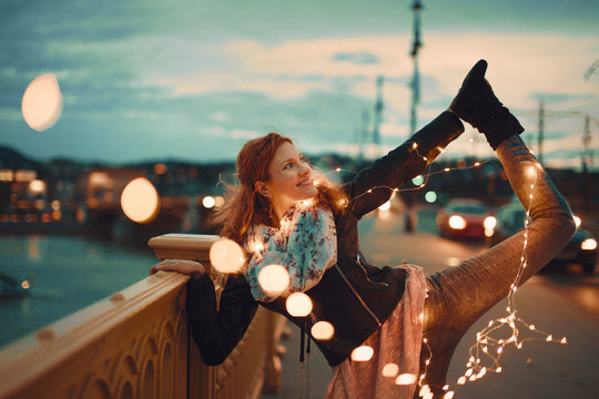 Redhead woman with garland fairy lights doing yoga vintage style