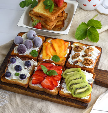 toasts with soft cheese, strawberries, kiwi, walnuts, cherries and blueberries