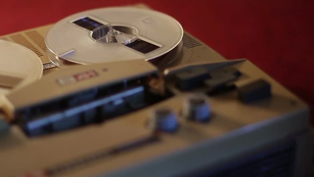 Playing a reel tape on an old tape recorder.