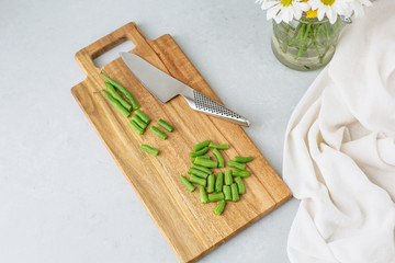 Fresh Green Beans on a Cutting Board against a Gray Background