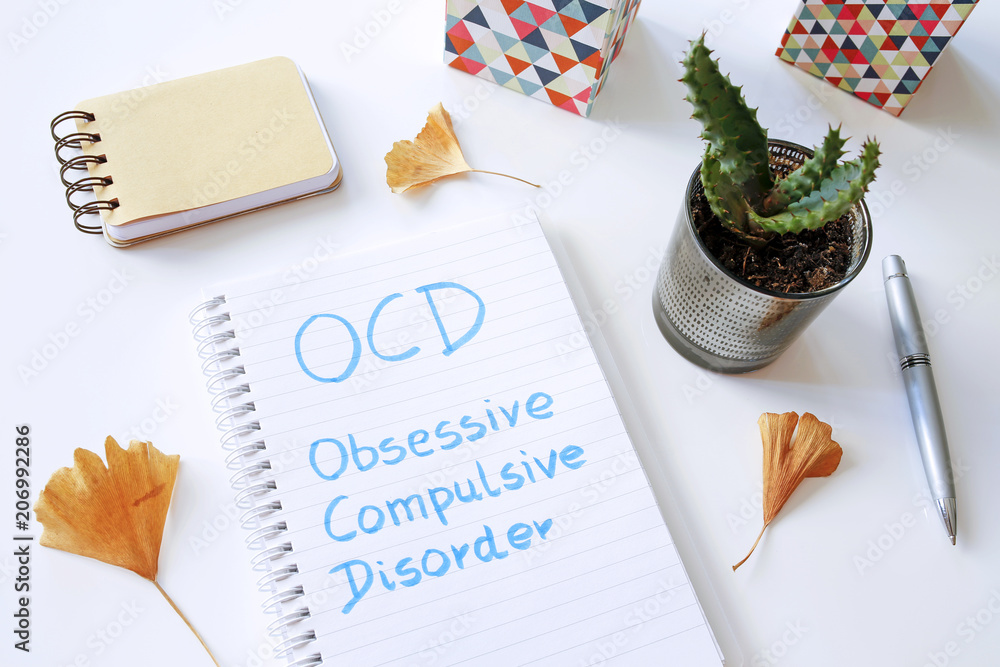 Poster ocd obsessive compulsive disorder written in notebook on white table