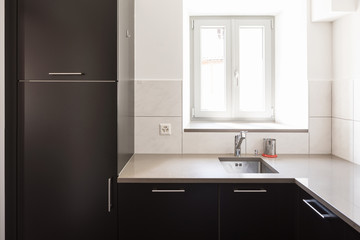 Dark kitchen with many doors and white tiles like parasolizzi