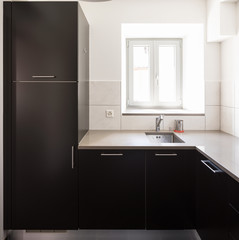 Dark kitchen with many doors and white tiles like parasolizzi