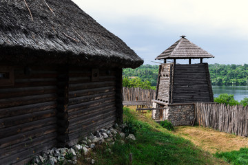 Fototapeta na wymiar ancient fortification of a wooden palisade, of Cossack state guard army troop. Panoramic view from Khortytsia island on broad Dnipro summertime, wooden church and houses construction technology