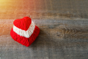 Obraz na płótnie Canvas Red, white, thread heart on dark wooden vintage background. Handmade pretty heart. Love, romance, Valentines day, wedding, honeymoon, DIY concept. Selective focus
