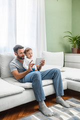 Obraz premium Father and Baby Looking at Tablet