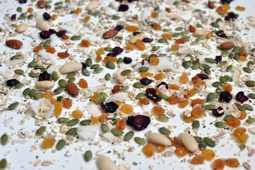 Randomized seeds and cereals on the white table, selective focus, close up view