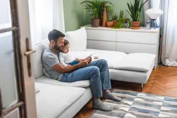 Obraz premium Father and Baby Looking at Tablet