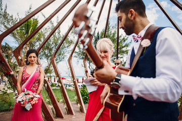 Groom plays on a guitar for bride during the wedding ceremony